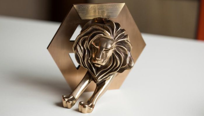 CANNES, FRANCE, JUNE 22, 2018: Cannes Lion trophy on desk, communication and advertising creative festival, international festival of creativity