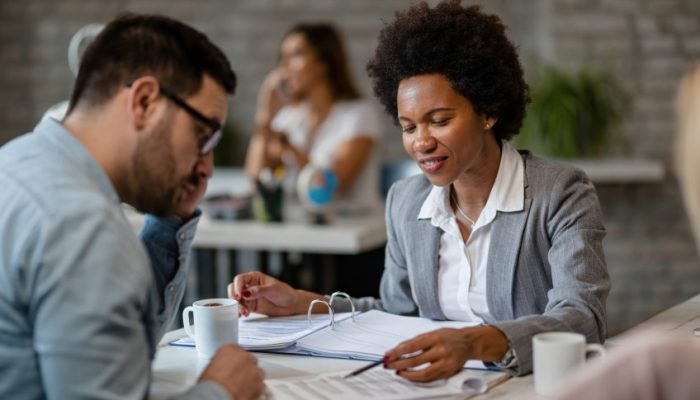 happy-african-american-bank-manager-analyzing-contract-terms-with-her-client-meeting-office-scaled_p.jpeg