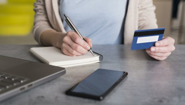 high-angle-woman-home-holding-credit-card-writing-notepad-scaled_p33237_thumb_resized.jpg
